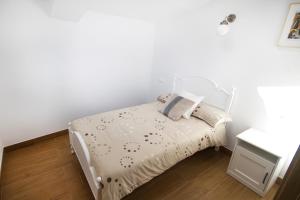 a white bed in a bedroom with a white wall at Casa Monica in Carnota