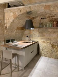 a kitchen with a table and a sink in a room at Petra Oikia in Corigliano dʼOtranto