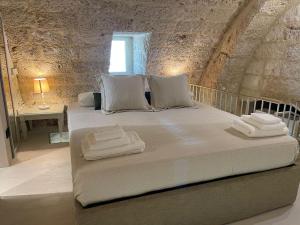 a bedroom with a large bed with towels on it at Petra Oikia in Corigliano dʼOtranto