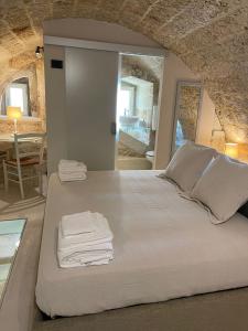a bedroom with a bed with towels on it at Petra Oikia in Corigliano dʼOtranto