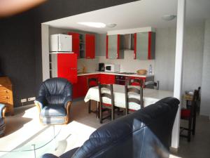 een keuken met rode kasten en een tafel en stoelen bij Hof ter Langeleye Planke in Damme