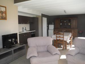 een woonkamer met 2 witte stoelen en een keuken bij Hof ter Langeleye Planke in Damme