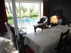 een eetkamer met een tafel en stoelen en een patio bij Hof ter Langeleye Planke in Damme