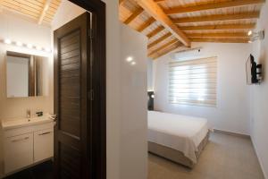 a bedroom with a bed and a bathroom with a window at AEGEAN Apartments - Bungalows in Alacati