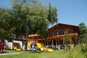 a person sitting in lawn chairs in front of a house at Valley Hostel in Lauterbrunnen