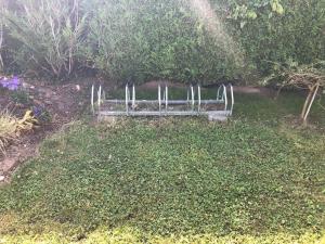 a park bench sitting in the middle of a yard at vieux colombier in Tournai