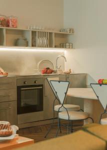 eine Küche mit 2 Stühlen, einem Tisch und einem Herd in der Unterkunft Pied A Terre - Palestro in Paris