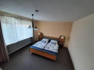 a small bedroom with a bed and a window at Fewo Rose in Norden