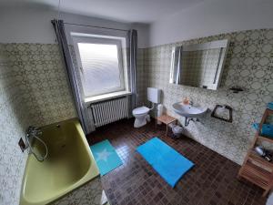 a bathroom with a green tub and a sink at Fewo Rose in Norden +15 photos