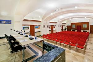 una sala conferenze con sedie e tavoli rossi in un edificio di Domus Australia a Roma