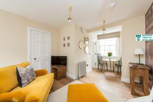a living room with a yellow couch and a table at The Riddoch Apartment by The National Trust Scotland in Edinburgh