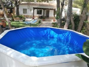 a blue swimming pool in a backyard with a house at Casa Pilar in Perelló