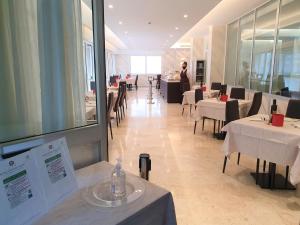 a restaurant with tables and chairs and a person in the background at Hotel Curtis Centrale in Alassio