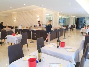 a woman standing at a counter in a restaurant at Hotel Curtis Centrale in Alassio