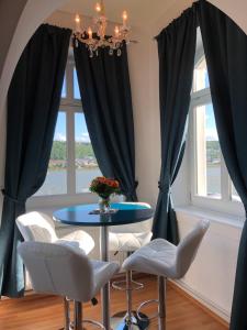 ein Esszimmer mit schwarzen Vorhängen sowie einem Tisch und Stühlen in der Unterkunft Villa Sturm Rüdesheim am Rhein in Rüdesheim am Rhein