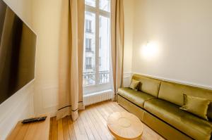 巴黎的住宿－Appartement de standing 1 – tour Eiffel/Invalides，客厅设有绿色沙发和窗户。