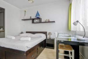 a bedroom with a bed and a desk with a lamp at Nice flat with terrace near the city centre of La Rochelle - Welkeys in La Rochelle