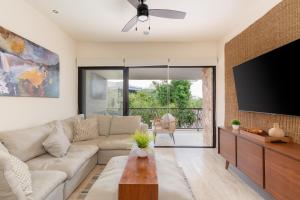 a living room with a couch and a flat screen tv at Exclusive Paramar VE Penthouse in Tulum by Lockey Best for Walking to Commercial Zone in Aldea Zama in Tulum