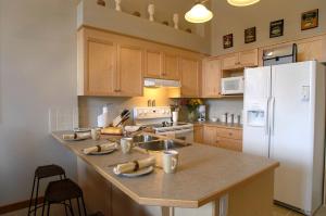 een keuken met houten kasten en een witte koelkast bij Apartment 411, Antique Heritage in Canmore