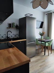 a kitchen with a stainless steel refrigerator and a table at L'escapade in La Bourboule