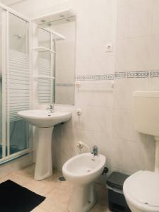 a white bathroom with a sink and a toilet at Oriente DNA Studios III in Lisbon