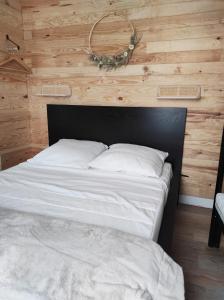 a bed in a room with a wooden wall at L'escapade in La Bourboule
