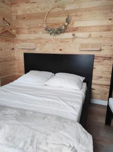 un lit dans une chambre avec un mur en bois dans l'établissement L'escapade, à La Bourboule 5 autres photos