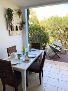 une table et des chaises blanches avec une table et une terrasse dans l'établissement Domaine des Restanques, suite parentale ,vue mer., à Grimaud