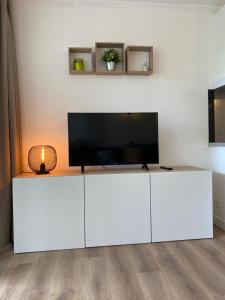 a white entertainment center with a flat screen tv on top at Domaine des Restanques, suite parentale ,vue mer. in Grimaud