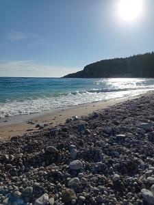 a beach filled with lots of rocks next to the ocean at Wave n' Sea Apartments in Himare