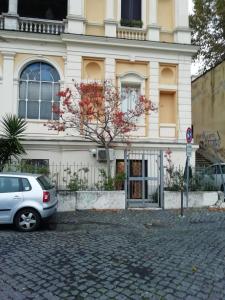 biały samochód zaparkowany przed budynkiem w obiekcie Marilyn's House 2 w mieście Frascati