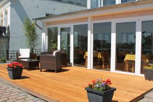 een houten terras met stoelen en bloemen op een huis bij Pension Villa Elisabeth in Sassnitz