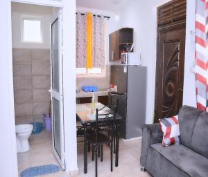 a living room with a table and a kitchen at Mtwapa Pride Apartment 4th Floor in Mtwapa