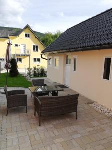 un patio con mesa y sillas y un edificio en Ferienhaus Am-moore en Steindorf am Ossiacher See