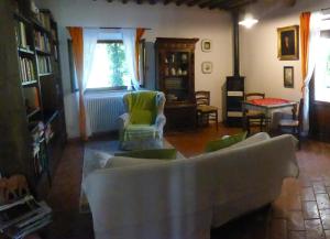 カステルヌオーヴォ・ディ・ヴァル・ディ・チェーチナにあるPodere Pian di Cavaのリビングルーム(ソファ、椅子、窓付)
