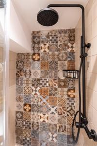 a shower in a bathroom with a tiled wall at IPELHOME - Rodi Boutique Apartment in Athens