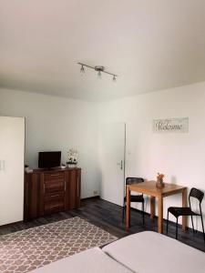 ein Wohnzimmer mit einem Tisch und Stühlen sowie einem TV in der Unterkunft MyCrib in Graz