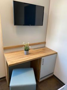 a desk with a television on a wall with a stool at besttime Hotel Monschau in Monschau