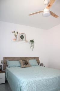 um quarto com uma cama e uma ventoinha de tecto em Apartamento Eucaliptus B - Delta del Ebro em L'Eucaliptus