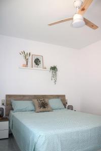 a bedroom with a bed and a ceiling fan at Apartamento Eucaliptus B - Delta del Ebro in L'Eucaliptus