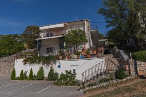 a white house with flowers on a wall at Apartmens Mendula in Senj