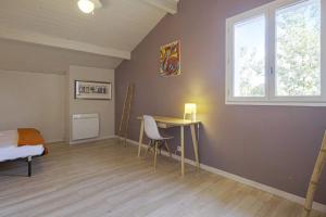 a bedroom with a desk and a bed and a window at La Maison du Marais - Welkeys in Labenne