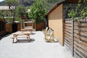 eine Gruppe Picknickbänke neben einem Gebäude in der Unterkunft T2 Cosy idéalement situé in Briançon