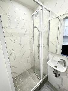 a bathroom with a shower and a sink at 1-комнатная уютная смарт квартира-студия in Kyiv