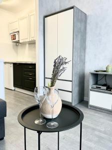 a table with two wine glasses and a vase on it at 1-комнатная уютная смарт квартира-студия in Kyiv