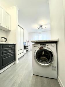 a kitchen with a washing machine in a kitchen at 1-комнатная уютная смарт квартира-студия in Kyiv
