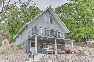 a gray house with a balcony on a hill at Serene Lake of the Ozarks Retreat with Private Dock! in Lake Ozark