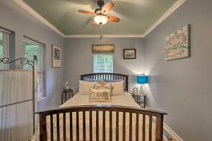 a bedroom with a crib with a ceiling fan at Renovated Home with Screened-In Patio on Hwy 90! in Quincy