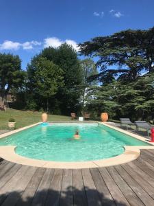 una persona en una piscina en una terraza de madera en Chateau des Janroux en Juliénas