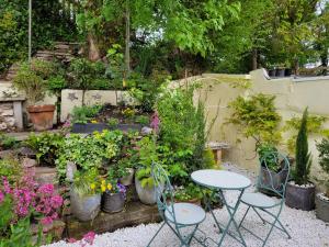 a garden with a table and chairs and plants at Sixpence Cottage in Penryn